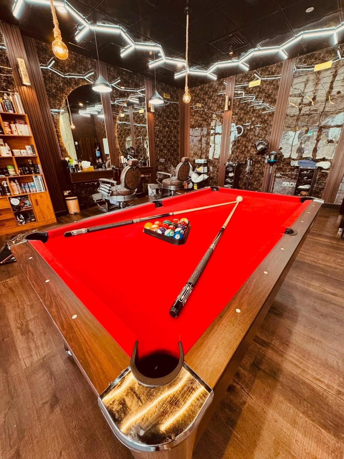 Red-felt pool table in the middle of the shop